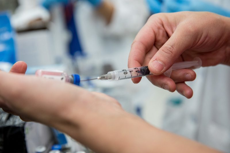 Syringe Syringe pulling medicine out of a vial.
